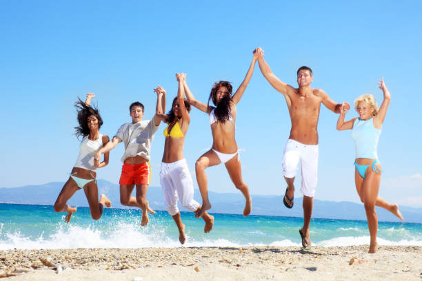 istock Large group of young people jumping on the beach. 183835561