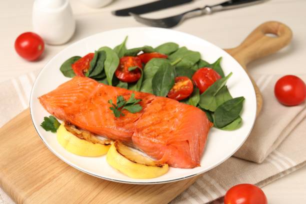 istock Tasty grilled salmon with basil, tomatoes and lemon on table 1838358880