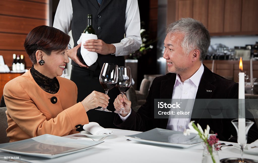 Happy mature Japaneese couple dating in the restaurant. Happy mature Japaneese couple dating in the restaurant.  Istockalypse Tokyo, Japan. Japanese Ethnicity Stock Photo