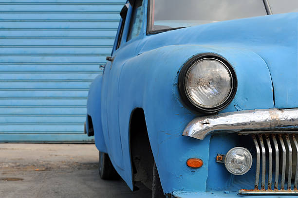 Rusty American oldtimer car in front of blue background stock photo