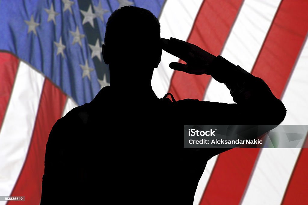 Silueta de un soldado hacer un saludo con bandera estadounidense - Foto de stock de Hacer el saludo militar libre de derechos