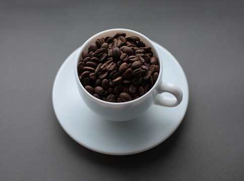 cup of coffee with coffee beans on a saucer