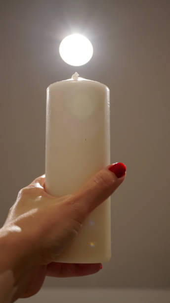 istock A hand holds a cylinder candle towards the light 1838371117