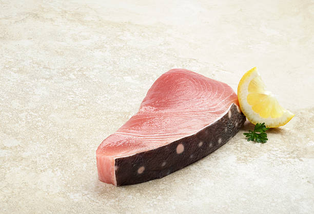 Piece of Fresh Opah Portion of fresh opah fish (moonfish) with its striking polka dotted skin showing. opah stock pictures, royalty-free photos & images