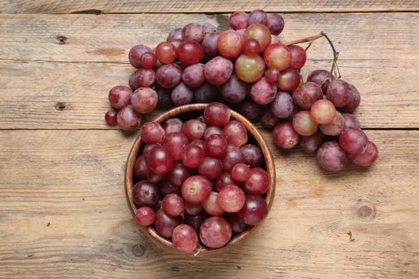 istock Delicious fresh red grapes on wooden table, flat lay 1838375326