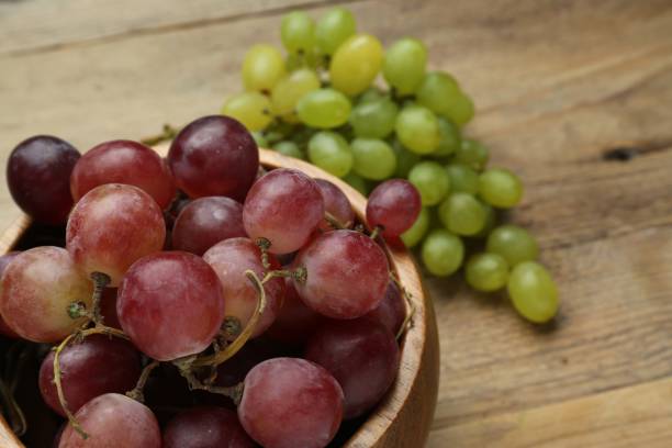 istock Different fresh ripe grapes on wooden table, closeup. Space for text 1838375861