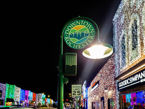 ミシガン州ロチェスターのダウンタウンにあるメインストリートのロチェスターロードにあるビッグブライトライトショーのロチェスターのダウンタウンの看板には、ホリデークリスマスラ� - street name sign small town america street street light ストックフォトと画像