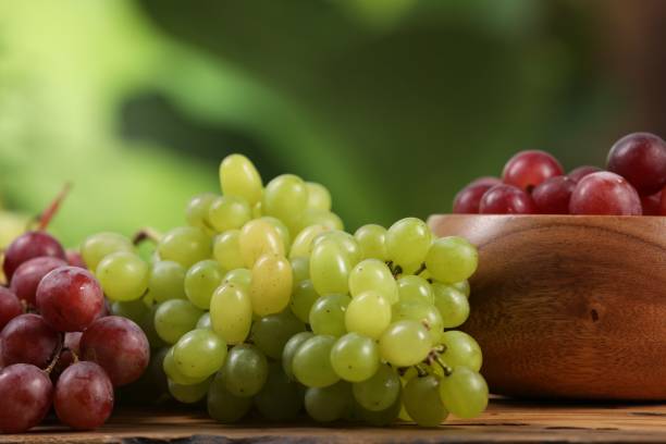 istock Different fresh ripe grapes on wooden table against blurred background, closeup 1838380168