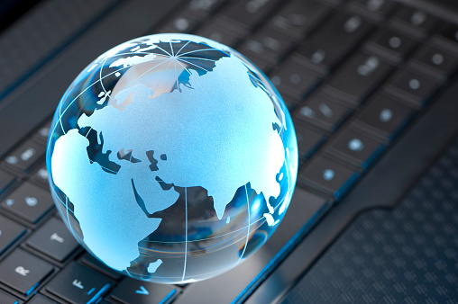 Glass Globe and Computer Keyboard with blue highlights showing Europe, Russia and Asia