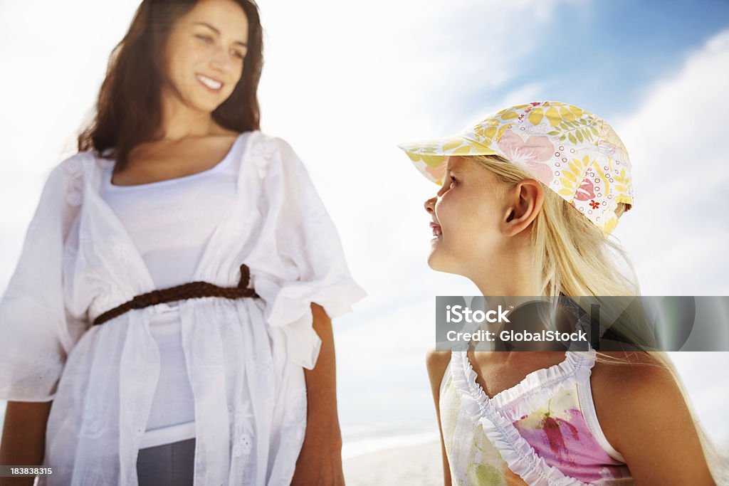 Mother and daughter looking at each other on a beach Low angle view of mother and daughter looking at each other on a beach 20-29 Years Stock Photo