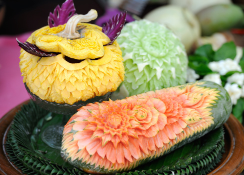 In Thailand the New Year is celebrated with the Songkran Festival. Here a lady has carved flowers in watermelons. This art has all been carved out of one piece. Very impressive! Shallow focus.