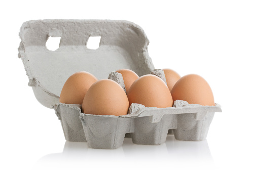 Six eggs in carton isolated on white with clipping path.
