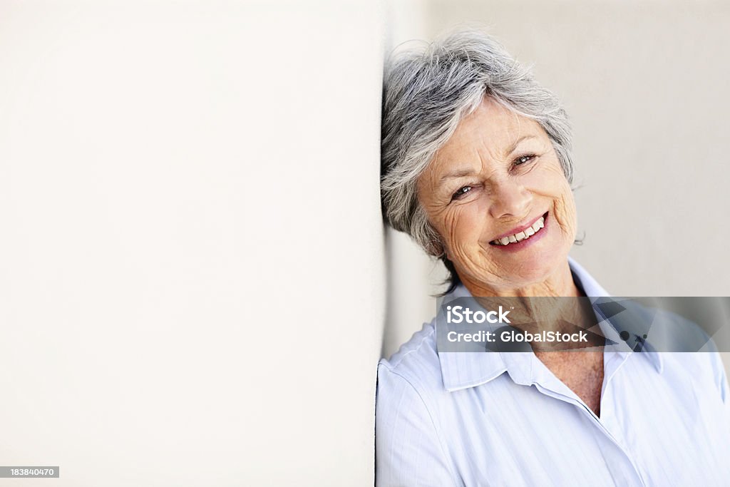 Zufrieden, business Frau schiefen gegen die Wand - Lizenzfrei 60-69 Jahre Stock-Foto