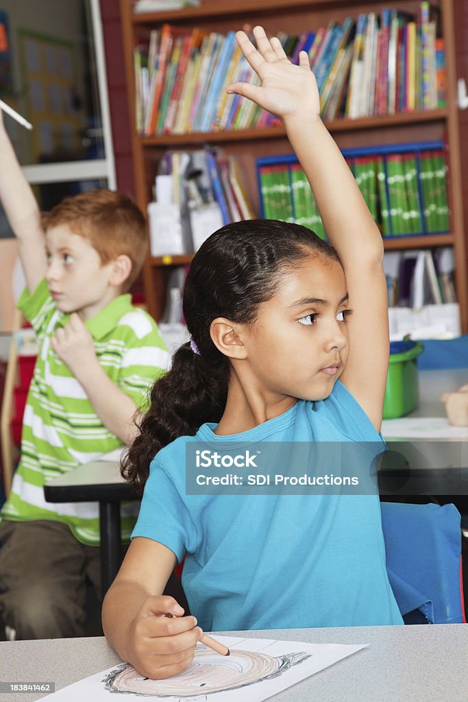 Young Girl elevar su mano en clase - Foto de stock de 6-7 años libre de derechos