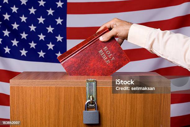 Human Hand Inserting Bible To Ballot Box Before American Flag Stock Photo - Download Image Now