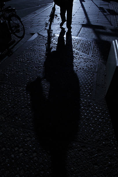 istock Cyclist alone on street corner in blue night shadows 183842178