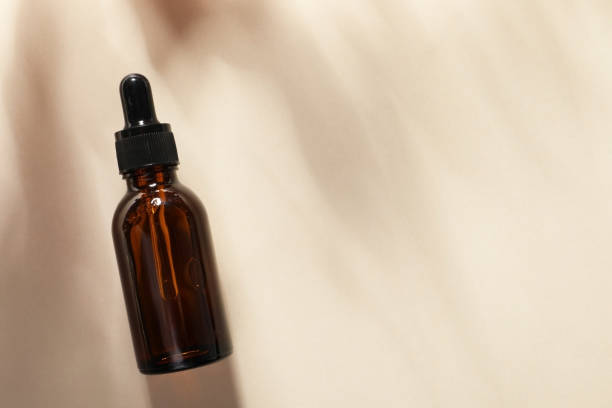 istock Bottle of cosmetic serum on beige background, top view. Space for text 1838425795