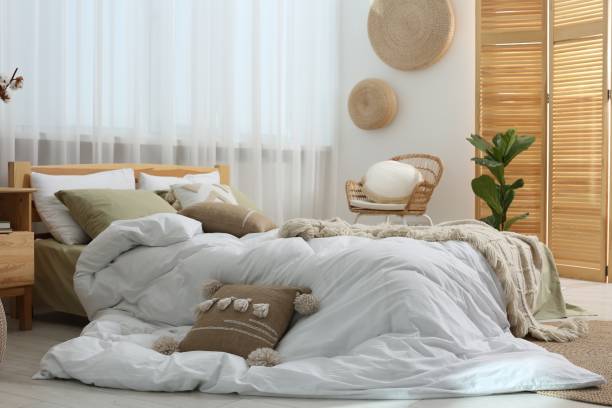 istock Large comfortable bed with soft pillows and blankets in room. Home textile 1838429991