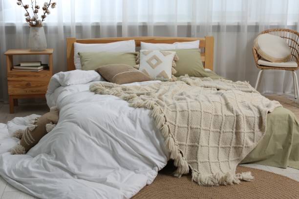 istock Large comfortable bed with soft pillows, duvet and blanket in room. Home textile 1838430012