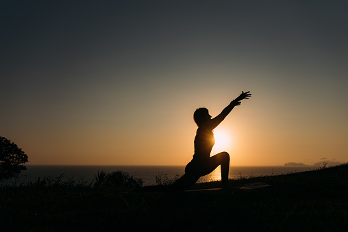 Latina full body woman practicing yoga stretching body at sunrise. Copy space.