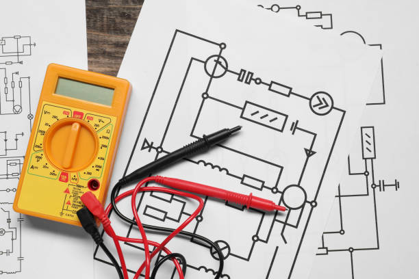 istock Wiring diagrams and digital multimeter on wooden table, flat lay 1838432688
