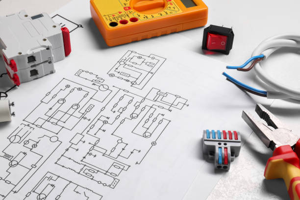 istock Wiring diagrams and different electrician's equipment on white table 1838433735