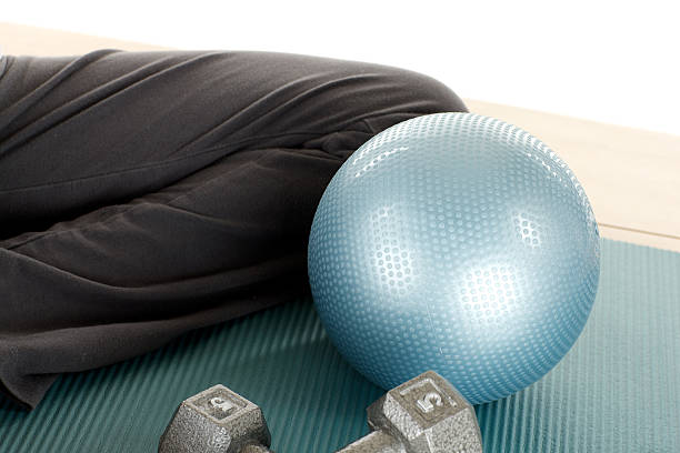 Collection of fitness accessories featuring black dumbbells, a green water bottle, and a foam roller on a clean white background, ideal for workout motivation