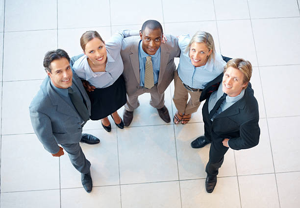 istock Smiling business colleagues with arms around each other 183843388