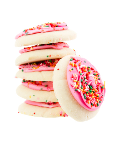 Stock photo of a stack of sugar cookies with pink icing and sprinkles.