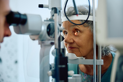 Elderly woman having her eyesight checked at ophthalmology clinic.