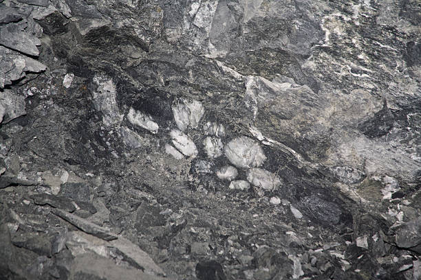 Gold is distributed around the round quartz mineral as a very fine grain. Gold mining is a very important industrial branch in South Africa. The working conditions are hard and difficult. The main work is done by black people. The ore is brought by a small railway  to the main shaft.