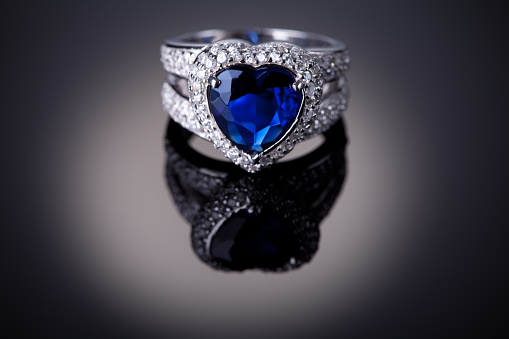 Elegance luxury ring with blue heart shaped sapphire. Small amount of noise added in post procesing for better look of background gradient.
