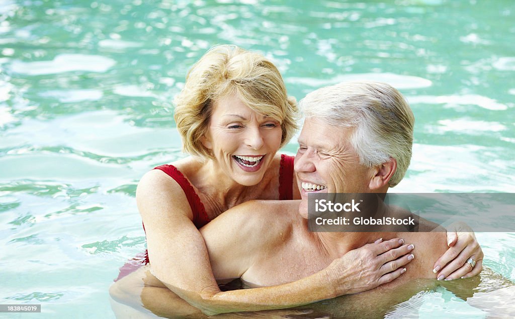 Coppia Senior godendo della piscina - Foto stock royalty-free di Nuoto