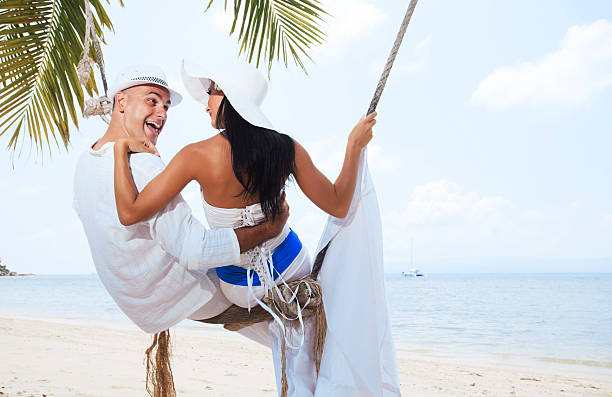 istock Beautiful couple swinging on the beach 183845037