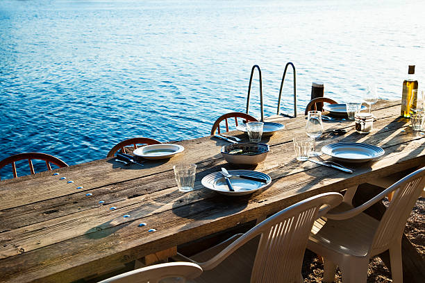 rustic wooden table with plates, glasses and cutlery, ready for dinner