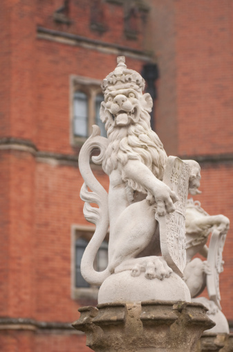 Vertical image of a lion statue in front of Hampton Court Palace in England. More images from England: