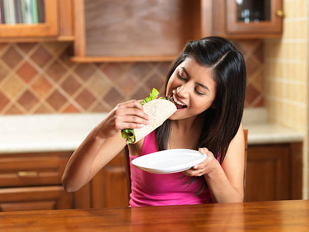 istock Beautiful woman eating a taco 183845758