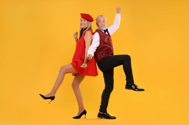 istock Senior couple dancing together on orange background 1838460741