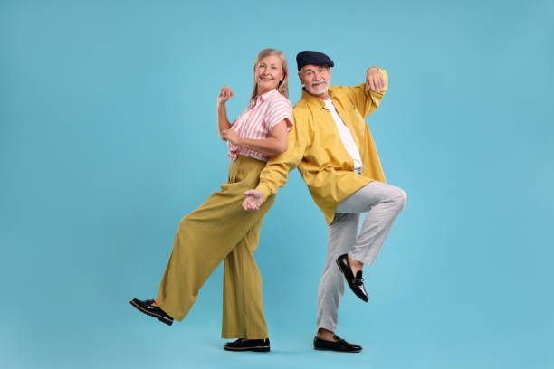 istock Senior couple dancing together on light blue background 1838460753