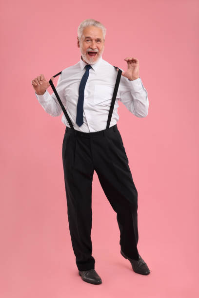 istock Emotional senior man dancing on pink background 1838461792