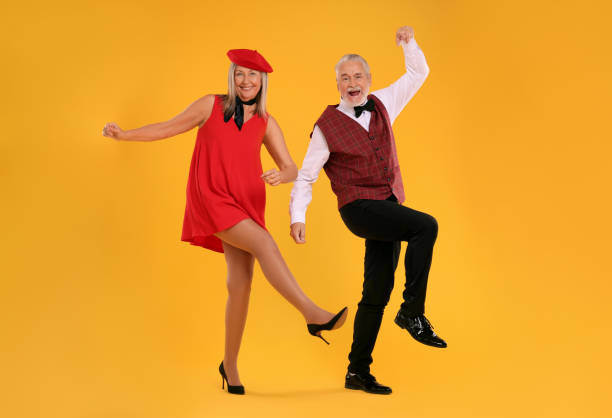 istock Senior couple dancing together on orange background 1838461814