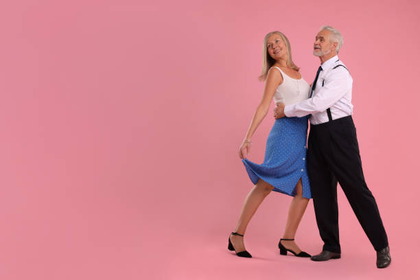 istock Senior couple dancing together on pink background, space for text 1838463963
