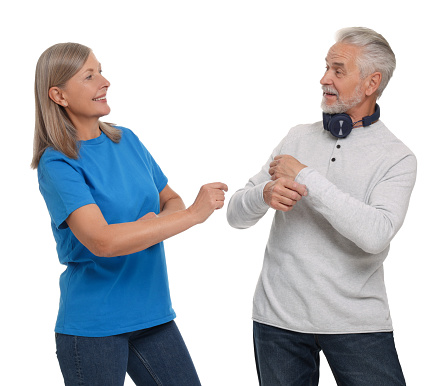 Senior couple dancing together on white background