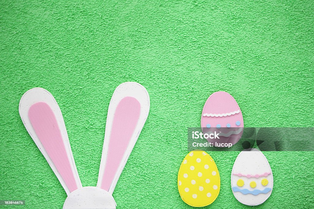 Huevos de Pascua y las orejas de conejo fondo verde - Foto de stock de Pascua libre de derechos
