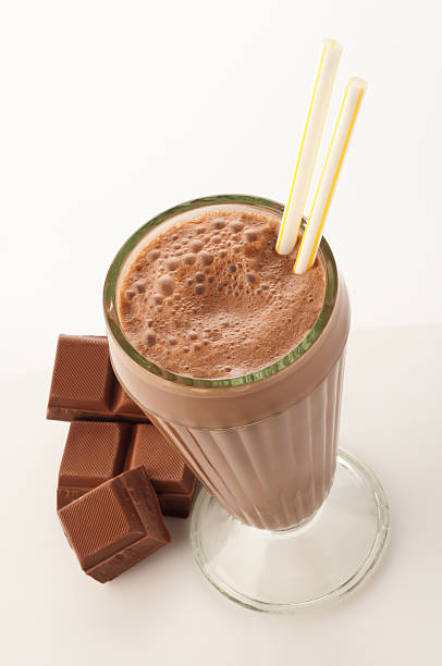 High angle view of chocolate milkshake glass on white backdrop Chocolate Milk Shake Smoothie with Chocolate Bar on White Background. High Angle View chocolate shake stock pictures, royalty-free photos & images
