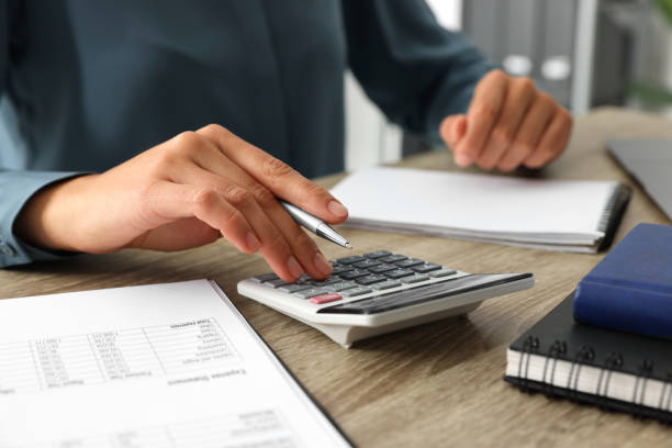 istock Woman using calculator at wooden table, closeup 1838482226