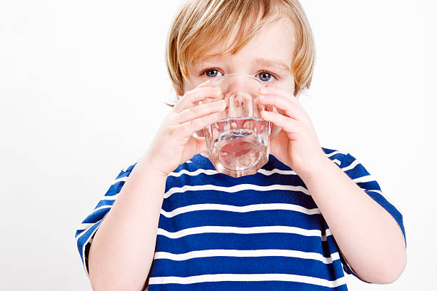 istock Little boy drinking a glass of water 183848383