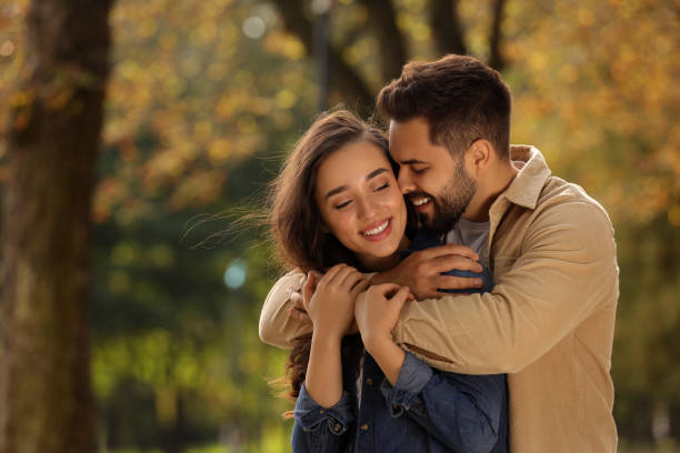 istock Beautiful couple hugging in autumn park, space for text 1838490087