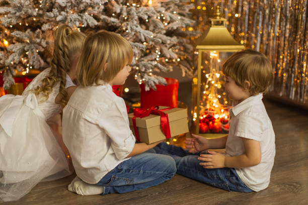 dzieci świętują boże narodzenie w domu. - child laughing blond hair three people zdjęcia i obrazy z banku zdjęć