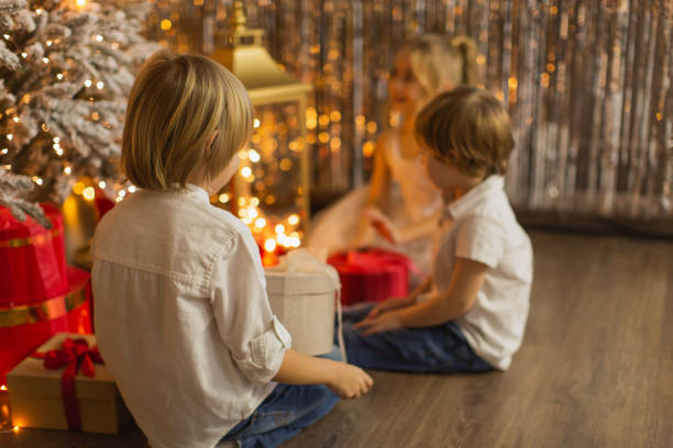 dzieci świętują boże narodzenie w domu. - child laughing blond hair three people zdjęcia i obrazy z banku zdjęć